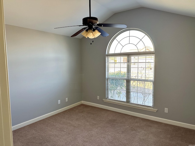 empty room featuring carpet floors, ceiling fan, baseboards, and vaulted ceiling