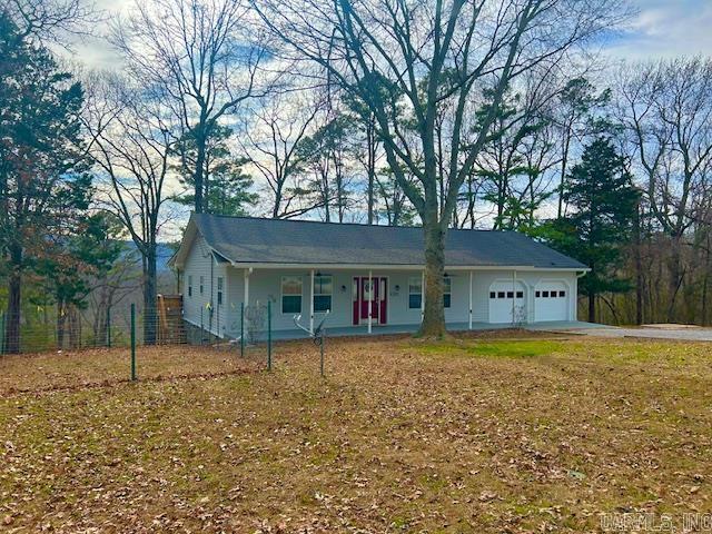 ranch-style house featuring a front lawn, a porch, and an attached garage