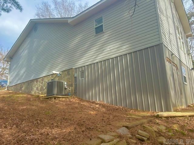 view of side of home with central AC