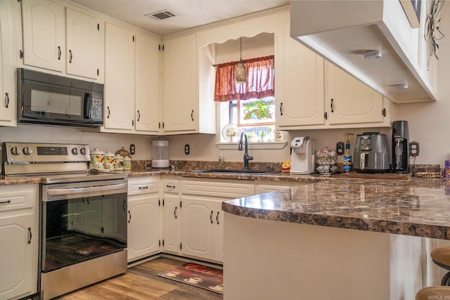 kitchen with white cabinets, dark countertops, stainless steel electric range oven, black microwave, and a sink