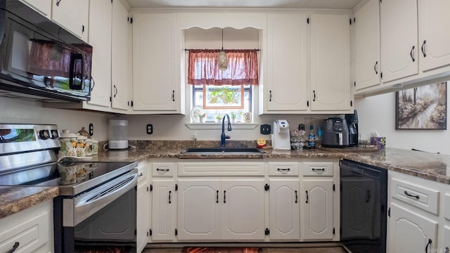 kitchen with black appliances, dark countertops, and white cabinets