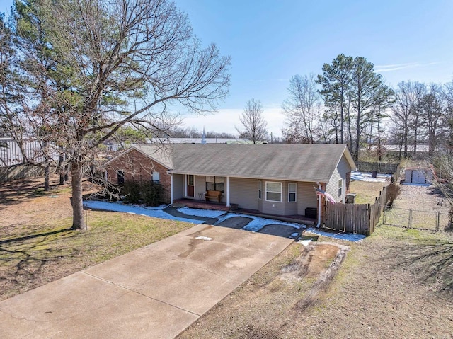 single story home featuring concrete driveway, a front lawn, and fence