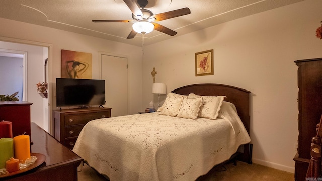 carpeted bedroom with ceiling fan and baseboards