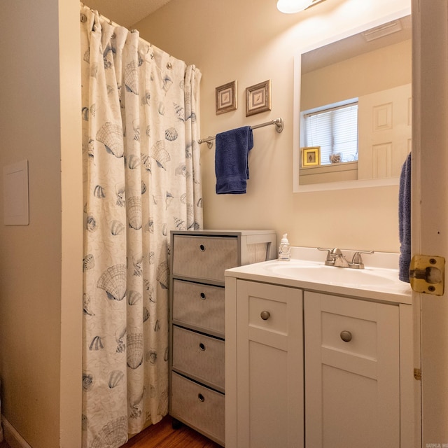 bathroom featuring a shower with shower curtain, visible vents, wood finished floors, and vanity