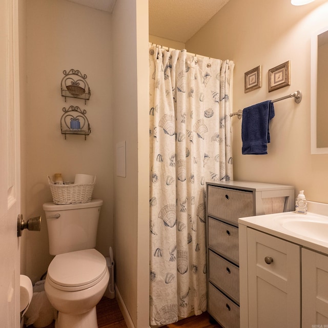 bathroom with toilet, curtained shower, baseboards, and vanity