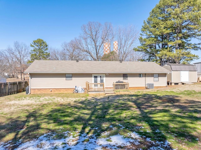 back of property featuring a yard, central air condition unit, a storage shed, fence, and a deck