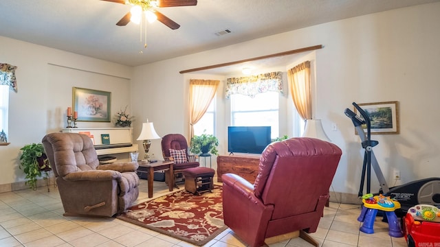 living room featuring ceiling fan, visible vents, and light tile patterned flooring