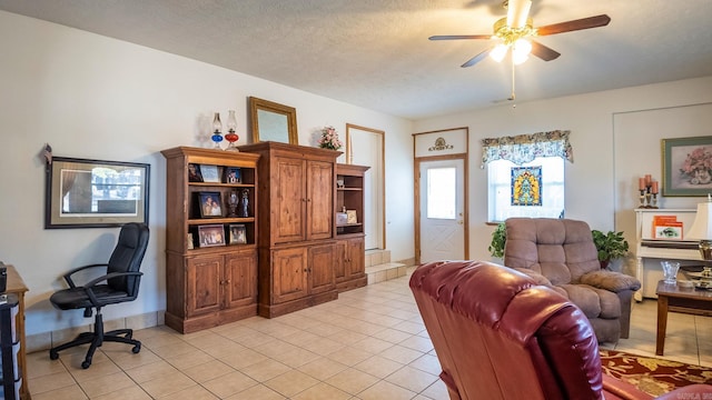 interior space with light tile patterned floors, ceiling fan, and a textured ceiling