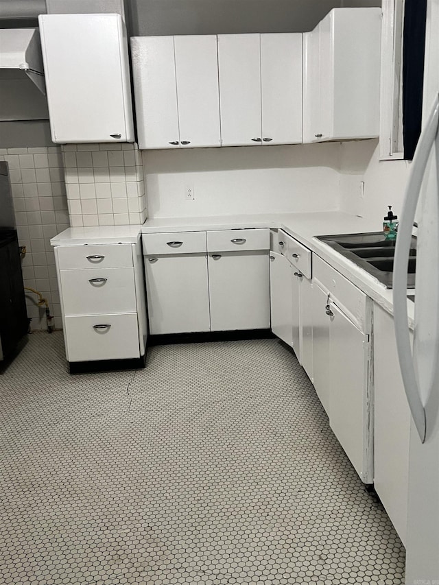 kitchen with white cabinets, light countertops, and a sink