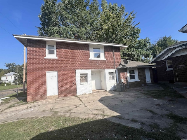 rear view of house with a patio, central AC, and brick siding