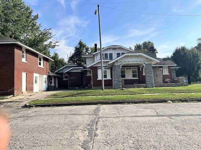 view of front facade featuring a front lawn, concrete driveway, and brick siding