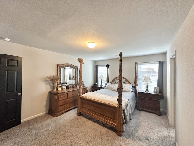 bedroom with a textured ceiling, carpet, and baseboards