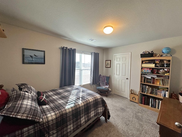 carpeted bedroom featuring visible vents and a textured ceiling