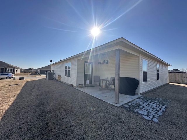 rear view of property featuring central AC, a patio, and fence