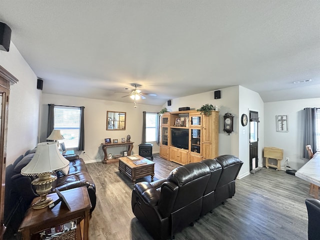 living room with a ceiling fan, wood finished floors, visible vents, and baseboards