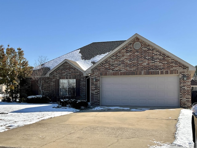 single story home featuring driveway, an attached garage, roof with shingles, and brick siding