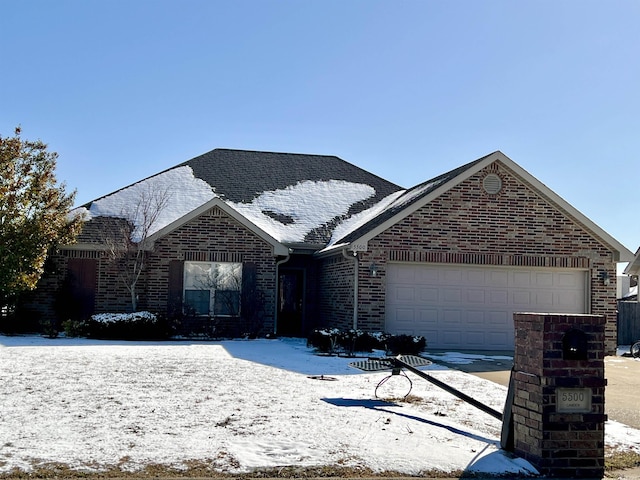 view of front facade featuring a garage, brick siding, and roof with shingles