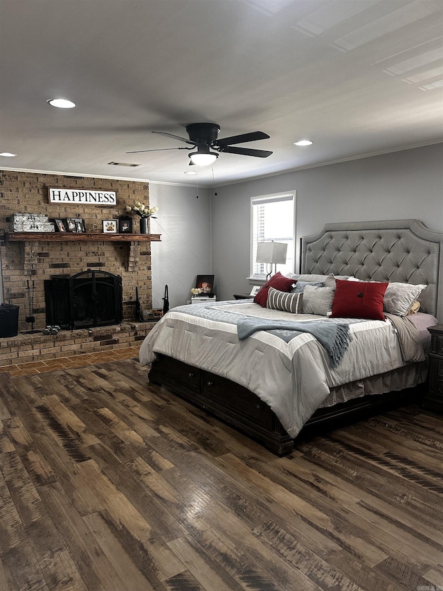 bedroom with dark wood-style floors and a brick fireplace