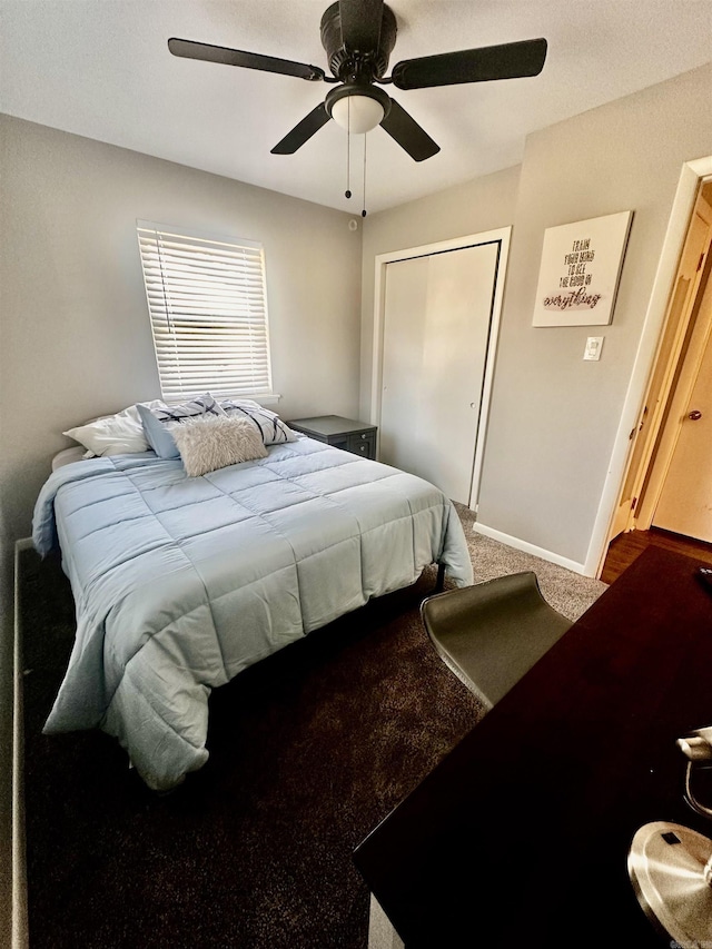 bedroom with a closet, carpet flooring, a ceiling fan, and baseboards