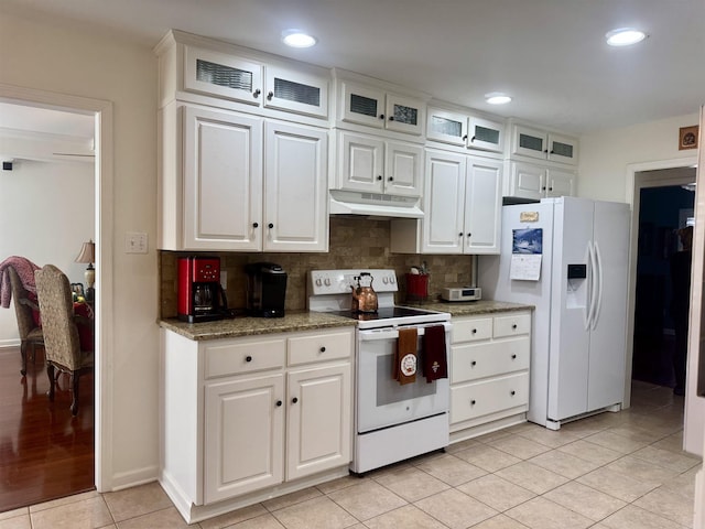 kitchen with glass insert cabinets, white appliances, under cabinet range hood, and white cabinetry