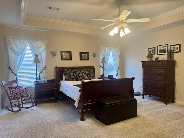 bedroom featuring light carpet, a raised ceiling, visible vents, and crown molding