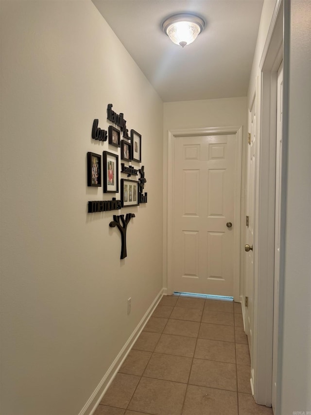 hallway with tile patterned flooring and baseboards