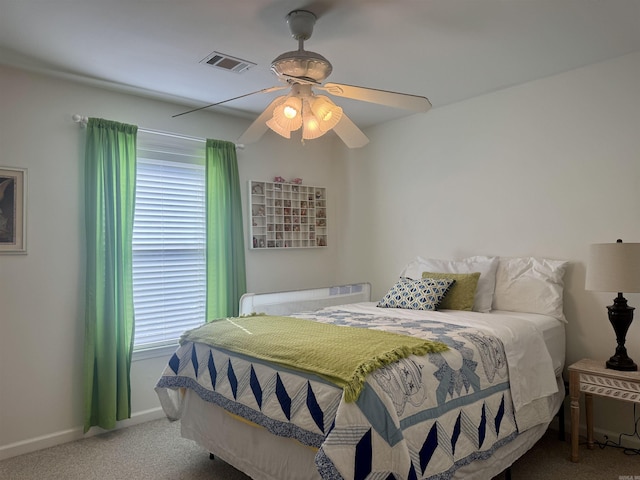 carpeted bedroom featuring baseboards, visible vents, and a ceiling fan