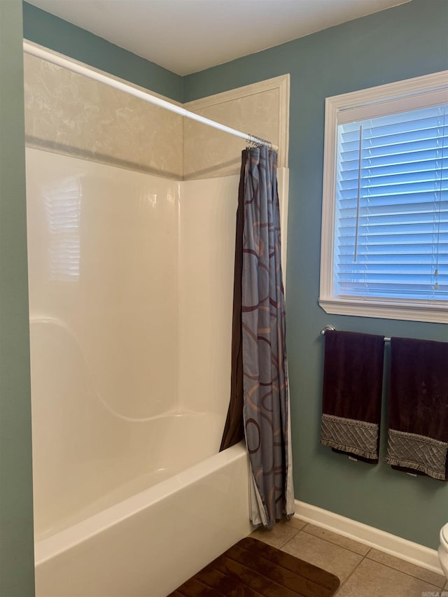 bathroom featuring tile patterned flooring, shower / bath combination with curtain, and baseboards