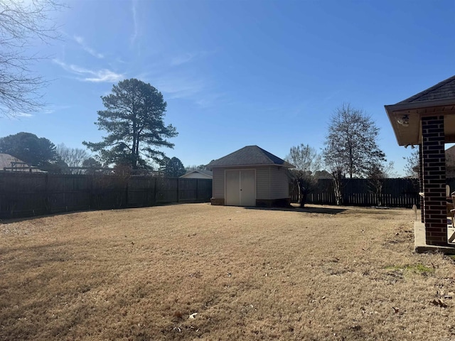 view of yard with a shed, a fenced backyard, and an outdoor structure