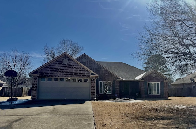 ranch-style home with driveway, brick siding, an attached garage, and fence