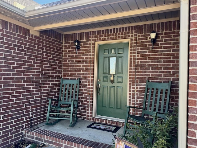 entrance to property featuring brick siding