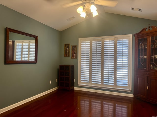 unfurnished room featuring dark wood-type flooring, visible vents, vaulted ceiling, and baseboards