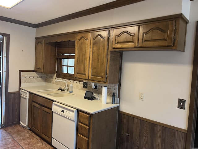 kitchen with light countertops, wainscoting, white dishwasher, a sink, and dark brown cabinets