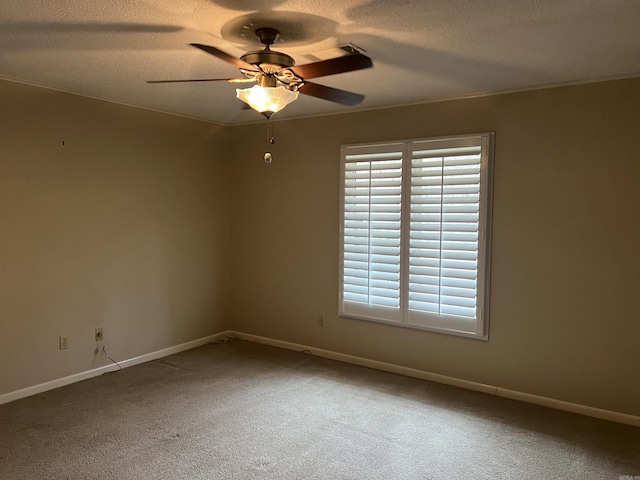 carpeted spare room with a textured ceiling, ceiling fan, crown molding, and baseboards