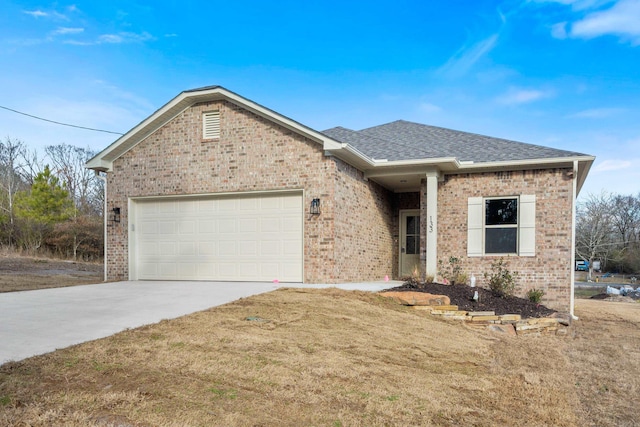 ranch-style house featuring an attached garage, a shingled roof, brick siding, concrete driveway, and a front lawn