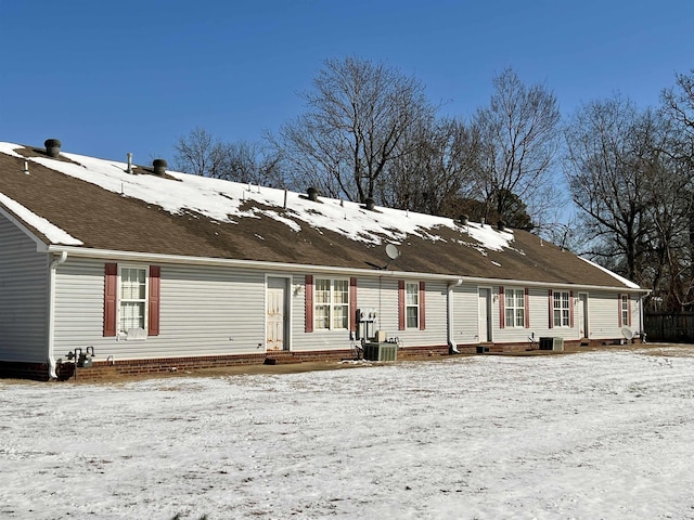 snow covered back of property featuring entry steps and cooling unit