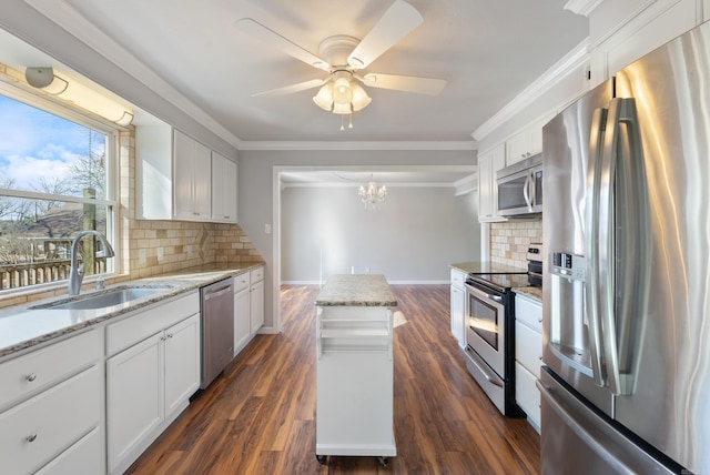 kitchen featuring a kitchen island, a sink, white cabinetry, appliances with stainless steel finishes, and light stone countertops