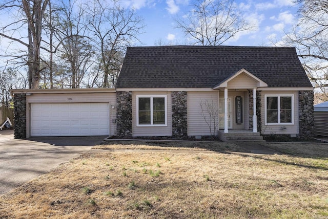 cape cod house with a shingled roof, concrete driveway, a front lawn, and an attached garage