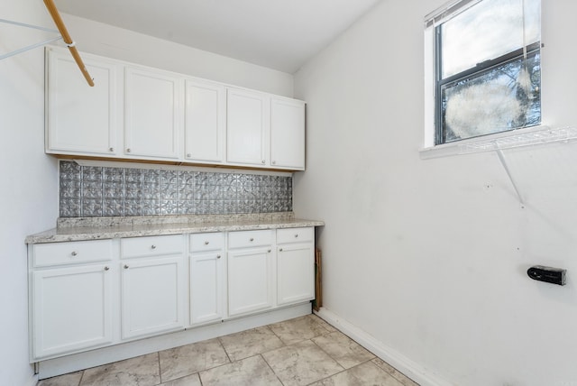 laundry room with baseboards