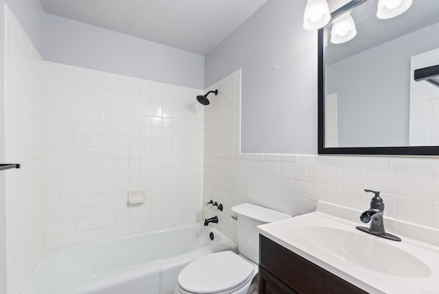 bathroom featuring toilet, shower / washtub combination, tile walls, and vanity