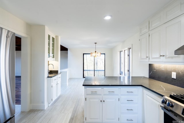 kitchen featuring glass insert cabinets, dark countertops, and white cabinetry