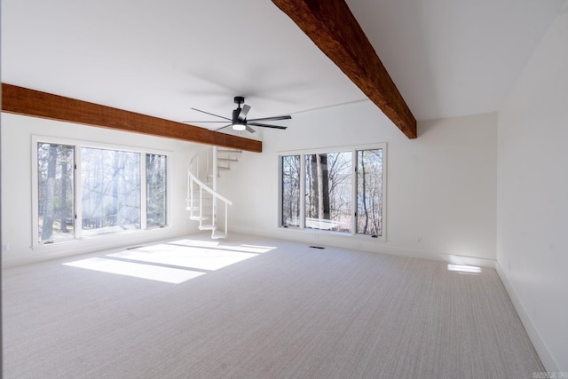 unfurnished living room featuring a wealth of natural light, carpet flooring, beamed ceiling, and stairway