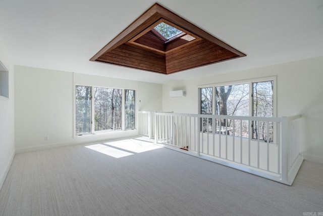 empty room with light carpet, a healthy amount of sunlight, and an AC wall unit