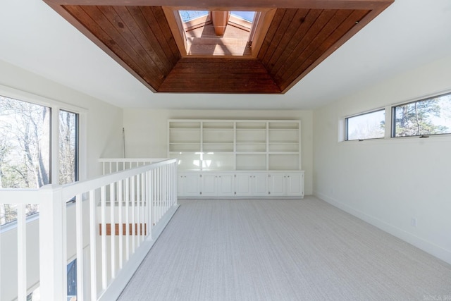 interior space featuring light colored carpet, wood ceiling, and a raised ceiling