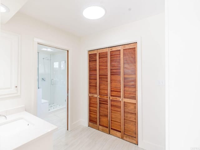 bathroom featuring a closet, a shower stall, vanity, and baseboards