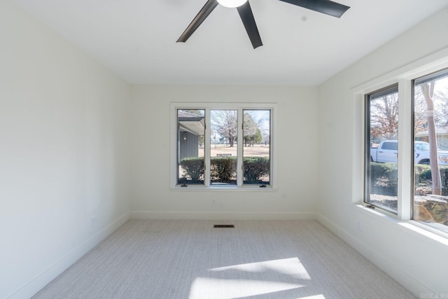 empty room featuring baseboards, a wealth of natural light, and light colored carpet