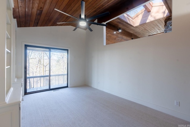 spare room featuring ceiling fan, wooden ceiling, light colored carpet, baseboards, and lofted ceiling with skylight