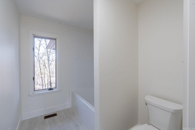 full bath featuring a wealth of natural light, baseboards, visible vents, and toilet