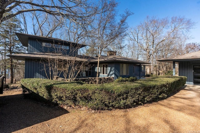 exterior space with board and batten siding and a chimney