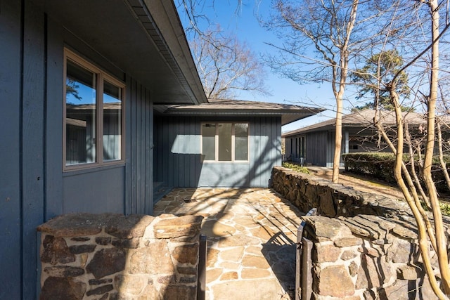 view of side of property with board and batten siding and a patio